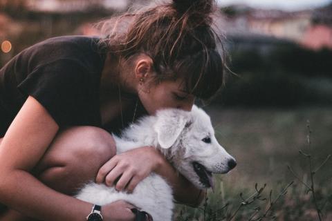 Girl hugging small white dog